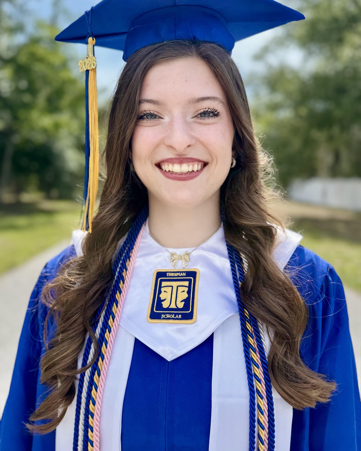 Abrianna Hart, Valerie Players scholarship recipient, in cap and gown wearing her International Thespian Society Scholar patch